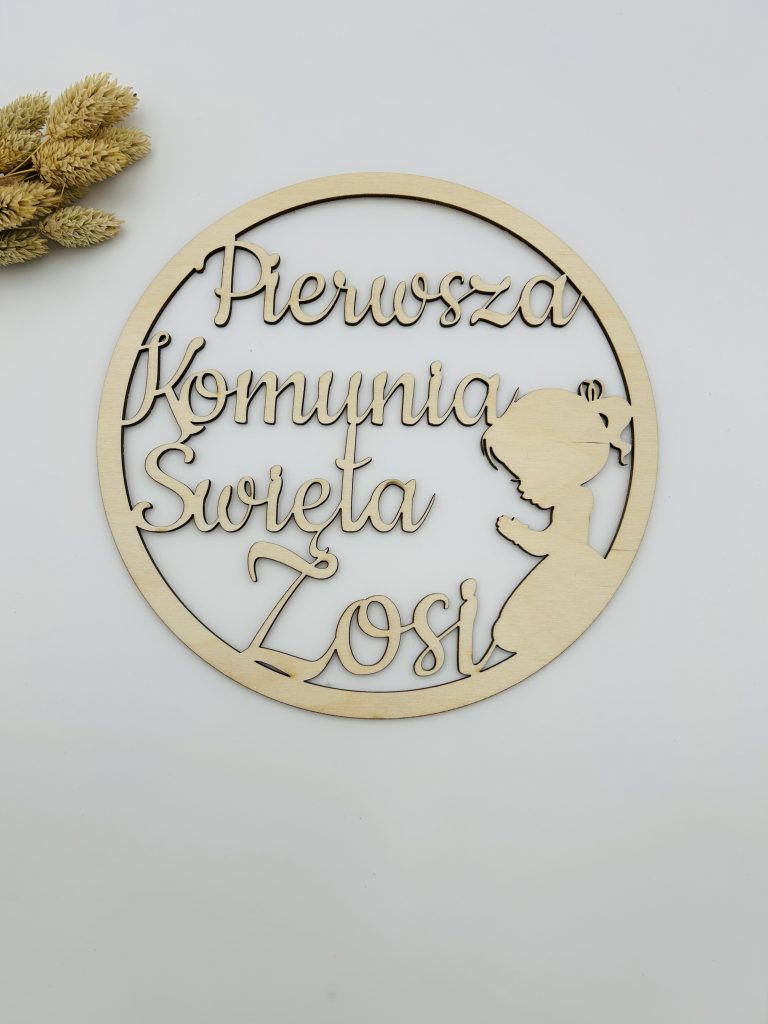 Tablica z wyciętym napisem „Pierwsza Komunia Święta” dla dziewczynki